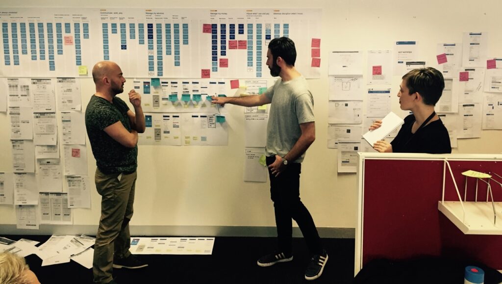 photo of the wall of a war room, where the software architect, the head of content, and the UX researcher are discussing how things fit together, using the mental model skyline as a visual organizing tool